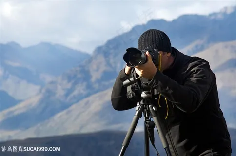 山峰上职业人物拿相机摄影师图片