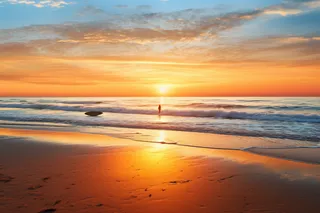 夏日夕阳晚霞沙滩海边摄影图