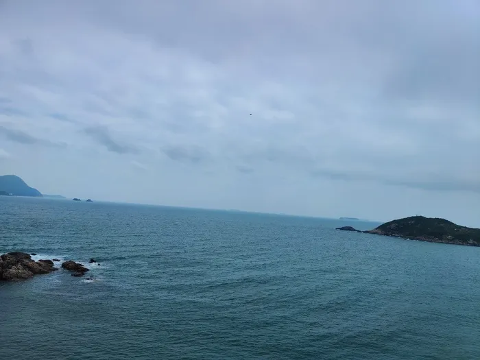 船 大海 岩石 阴天 水有点蓝 站在高处放眼望去，心情很放松