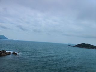 船 大海 岩石 阴天 水有点蓝 站在高处放眼望去，心情很放松