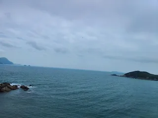 船 大海 岩石 阴天 水有点蓝 站在高处放眼望去，心情很放松