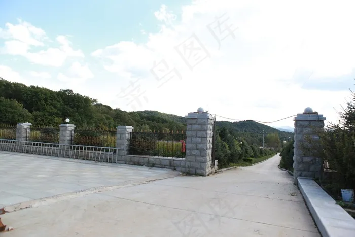 蓝天白云下山脚边的水泥路