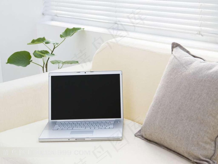 沙发上的笔记本电脑与抱枕