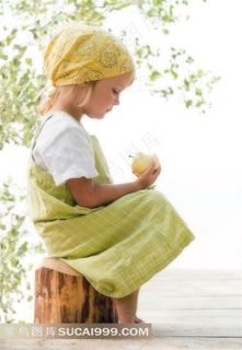 坐在树桩上拿着苹果的小女孩