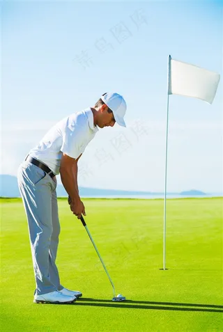 草坪上打高尔夫球的男士和旗杆高清图片