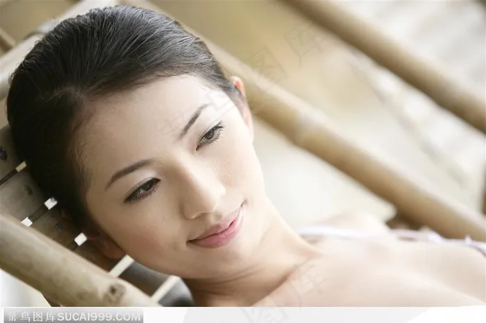 倚在竹靠椅上享受的女子