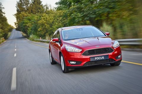 行驶在郊区道路中的红色福特福克斯