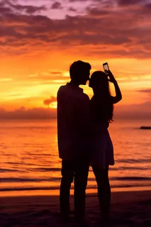 夕阳落日海边的情侣拍照唯美晚霞摄影图