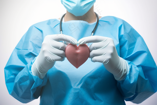 手术医生手握红色爱心医疗摄影图
