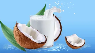 白色新鲜椰奶波浪溅与椰子隔离摄影图