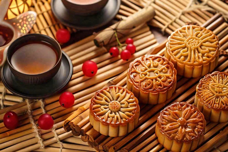 中国传统糕点月饼竹制托盘上的茶杯中秋节摄影图(1344x896)
