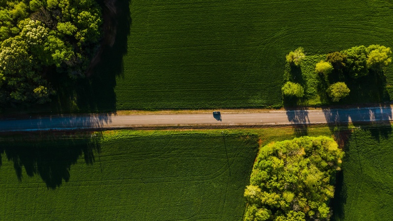 航拍麦田间的小路上行驶的汽车