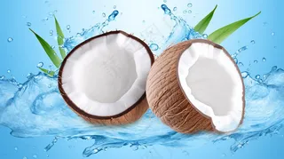 白色新鲜椰汁波浪溅与椰子隔离特写摄影图