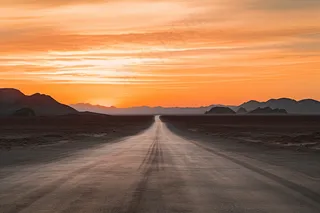 延绵的公路夕阳落日余晖晚霞摄影图