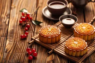 中国传统糕点月饼竹制托盘上的茶杯中秋节摄影图