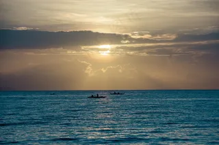余晖映照平静海面的小舟