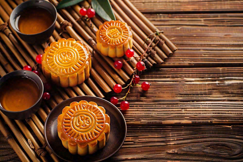 中国传统糕点月饼竹制托盘上的茶杯中秋节摄影图