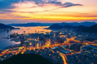 夕阳傍晚下沿海城市灯火车水马繁华龙落日余晖摄影图