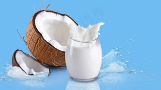 白色新鲜椰奶波浪溅与椰子隔离摄影图