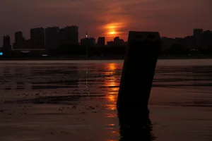 落日后的河边橙色的夕阳倒映在水面上