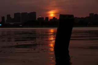 落日后的河边橙色的夕阳倒映在水面上
