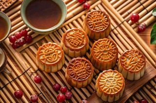 中国传统糕点月饼竹制托盘上的茶杯中秋节摄影图