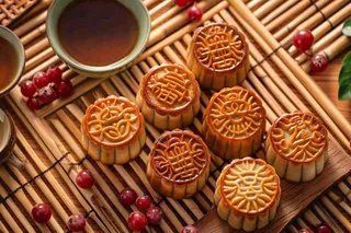 中国传统糕点月饼竹制托盘上的茶杯中秋节摄影图