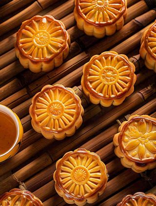 中国传统糕点月饼竹制托盘上的月饼中秋节木制背景摄影图