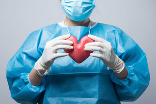 手术医生手握红色爱心医疗摄影图