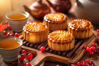 中国传统糕点月饼竹制托盘上的茶杯中秋节摄影图