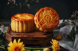 中国传统美食月饼中秋节菊花摆盘黑色背景摄影图