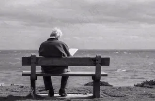 黑白简约坐着海边长椅看书的老人白发重阳节父亲节摄影图