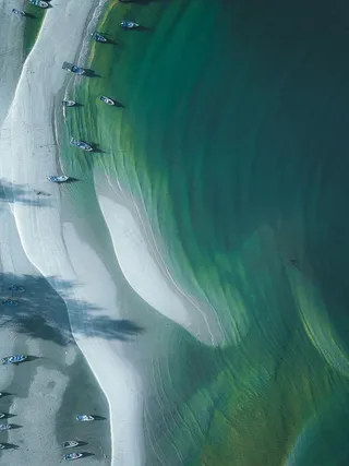 宁静海滩上的船只和波纹