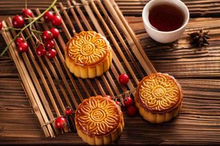 中国传统糕点月饼竹制托盘上的茶杯中秋节摄影图