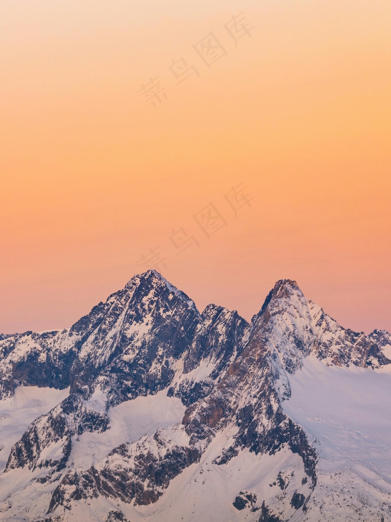 橙色天空下的巍峨雪山