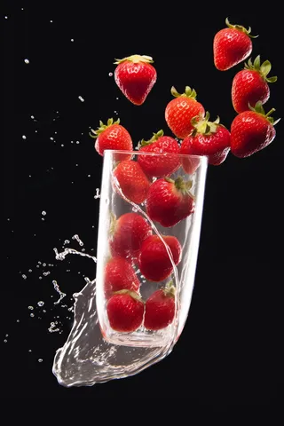 水杯里飞溅的草莓自来水摄影图