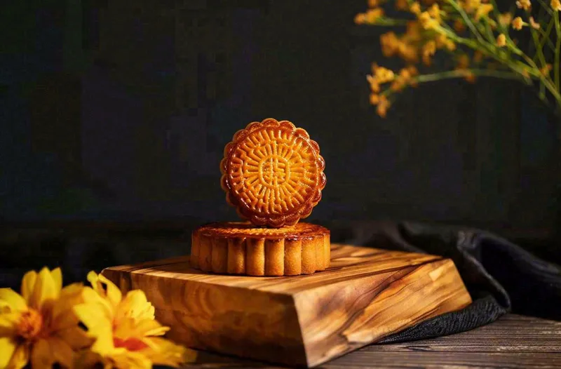 中国传统美食月饼中秋节菊花摆盘黑色背景摄影图(1360x896)