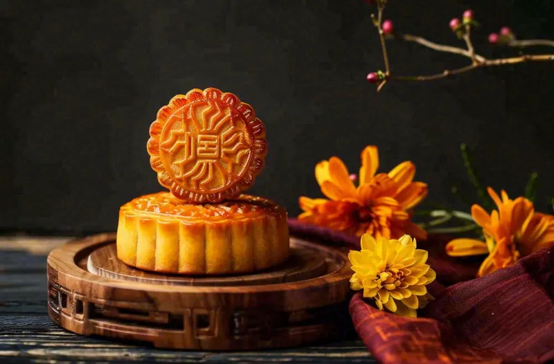 中国传统美食月饼中秋节菊花摆盘黑色背景摄影图(1360x896)