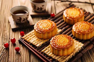 中国传统糕点月饼竹制托盘上的茶杯中秋节摄影图