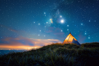 野外露营星空夜晚山顶的帐篷摄影图