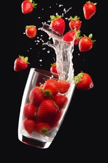水杯里飞溅的草莓自来水摄影图