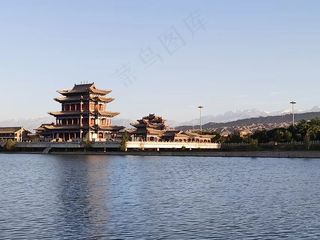 夕阳下的古建筑和雪山照片