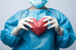 手术医生手握红色爱心医疗摄影图