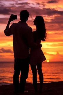 夕阳落日海边的情侣拍照唯美晚霞摄影图