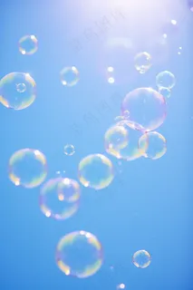 蓝天下飞行的肥皂泡梦幻摄影图
