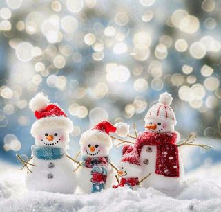 冬天雪地堆雪人唯美光圈温馨雪花飘零立冬冬至小雪大雪圣诞摄影图