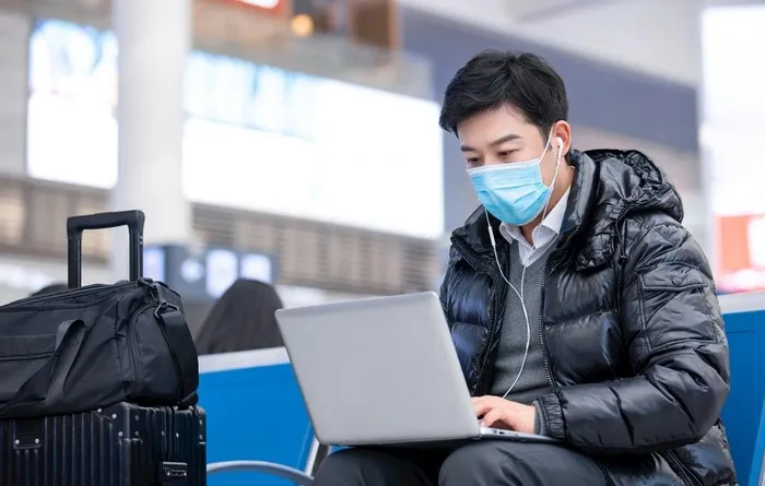 男性在候车厅使用笔记本电脑办公图片