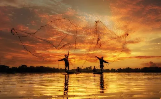 晚霞撒网的渔民图片