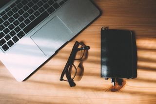 笔记本电脑，眼镜，圆珠笔在木桌上的笔记本的鸟瞰图