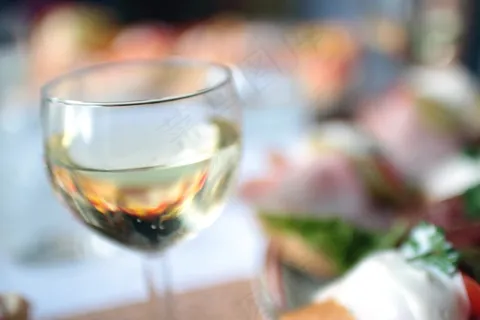 玻璃杯,酒杯,杯子,瓶子,玻璃烛台,白葡萄酒杯在花园里的桌子上的特写镜头